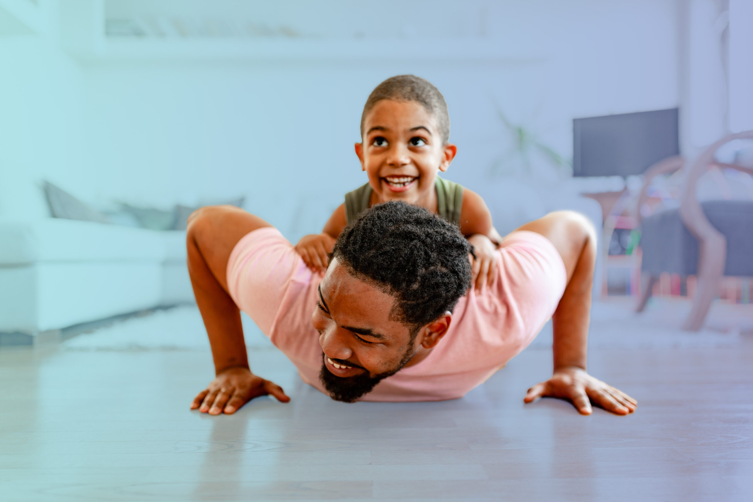 A man does a pushup with a child on his back