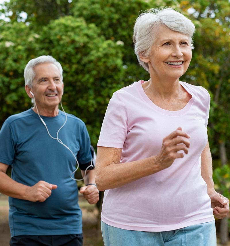 An older man and woman jog together
