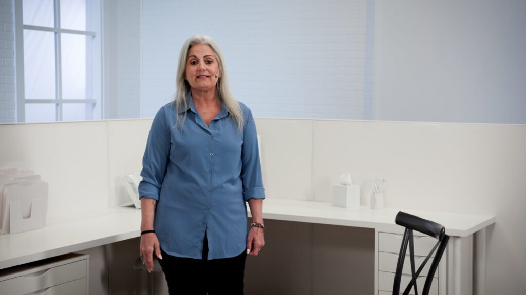 Wellbeats instructor Greta W. leads Clear Your Mind class while standing in an office workspace.