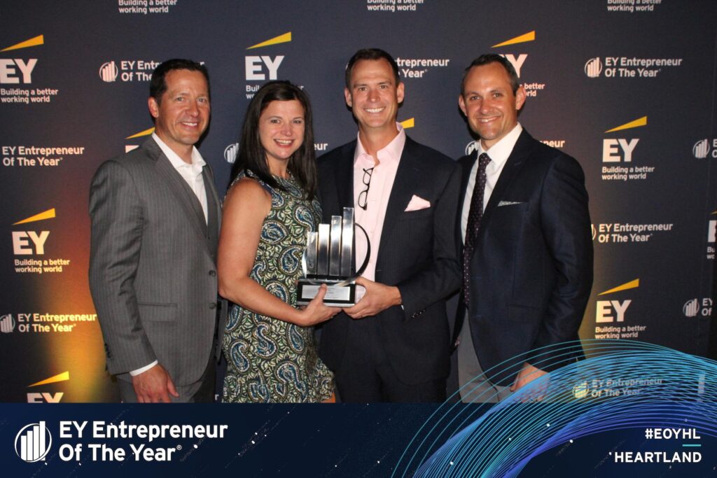 Wellbeats team members Jeff Kennefick, Jill Ross, Jason Von Bank, and Jason Campana pose in front of an EY backdrop at the EY Entrepreneur of the Year Heartland Awards ceremony.