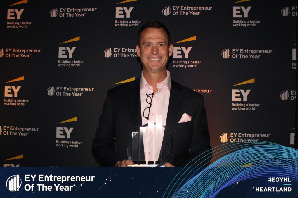 Wellbeats President and LifeSpeak COO Jason Von Bank smiles while holding his EY Entrepreneur of the Year Heartland Award.